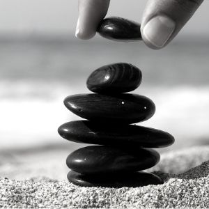 Finances on divorce represented as a a hand stacking pebbles by Divorce Finance & Children Solicitor, Keats Family Law